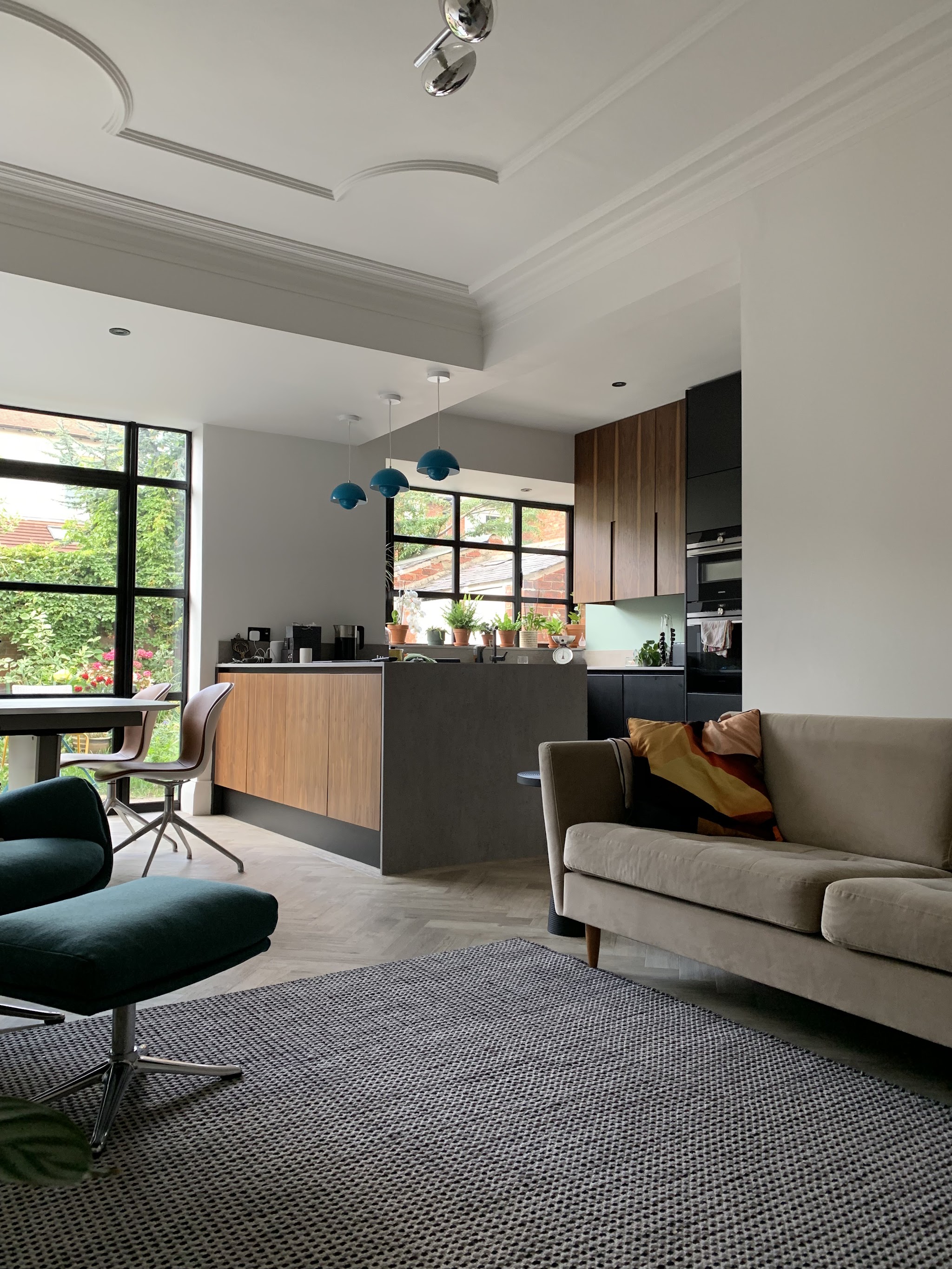 An open-plan kitchen and living room with a large steel-framed window wall